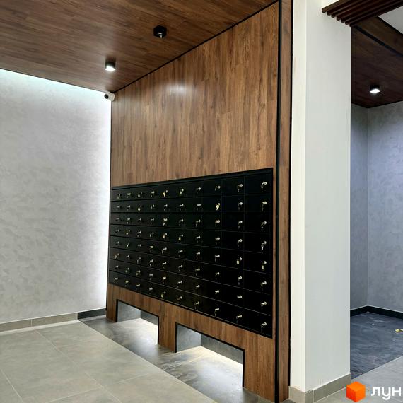 Комплекс Idilika Avenue з індивідуальними поштовими скриньками та дерев'яними елементами фасаду. Сучасний дизайн новобудови.