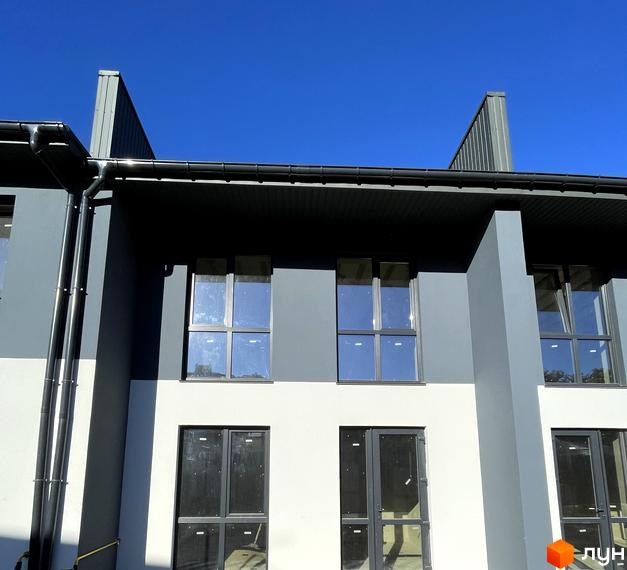 Фасад таунхаусів Belissimo з темно-сірим та світлим оздобленням, обладнаний водостічною системою та великими вікнами.