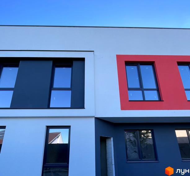 Фасад Таунхаусів Belissimo, що поєднує білі, темно-сірі та червоні панелі, з прямокутними вікнами.