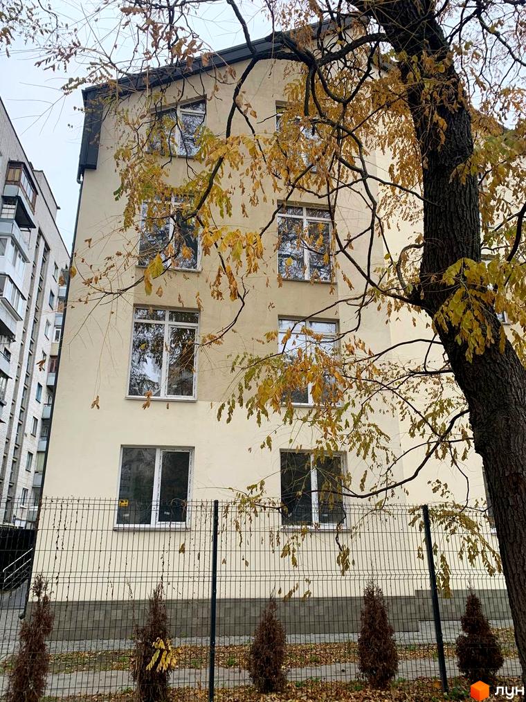 Клубний будинок „На Макіївській“ з жовтим листям на деревах та парканом на прибудинковій території.