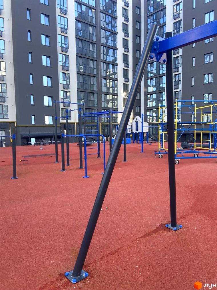 Житловий комплекс Comfort House з сучасною спортивною зоною та дитячим майданчиком на червоному покритті.