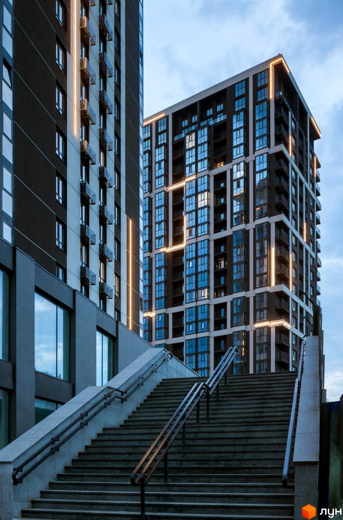 Житловий комплекс Avalon Up з підсвіченими фасадами та сходами, що ведуть до будівель. Сучасна архітектура новобудови.