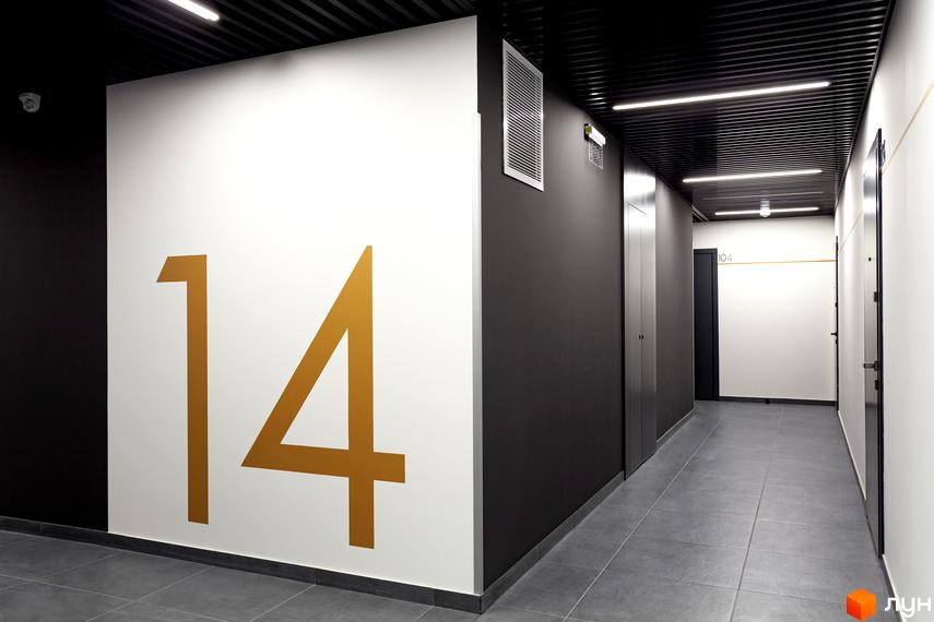 Житловий комплекс Avalon Up: коридор з номером 14 на стіні, двері та освітлення. Фото новобудови.