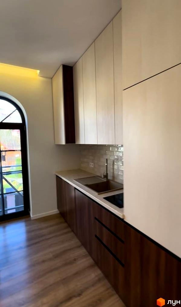 Інтер'єр кухні в Житловому комплексі Shayan lux house з темними шафами та великим вікном. Вигляд зсередини.