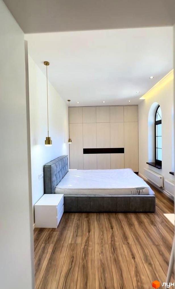 Житловий комплекс Shayan lux house. Спальня з великою шафою та двоспальним ліжком, підвісними лампами та арочним вікном.