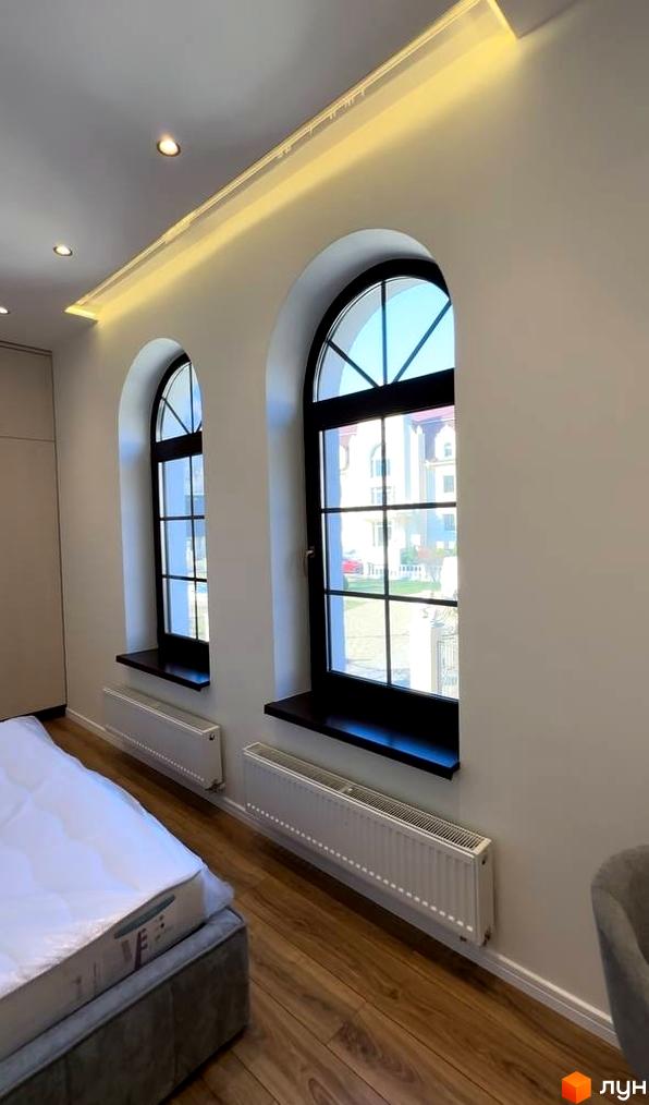 Інтер'єр кімнати з двома арочними вікнами в Житловому комплексі Shayan lux house. Вид на вулицю з вікон.