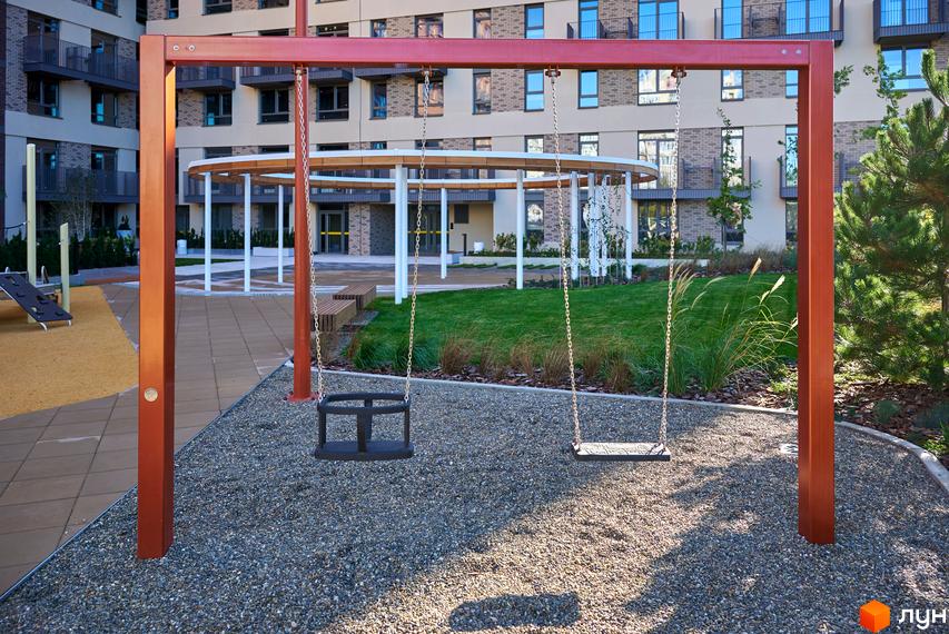 Будинок на Вавилових: багатоповерховий житловий комплекс з балконами. Прибудинкова територія має дитячий майданчик з гойдалками та зелену зону.