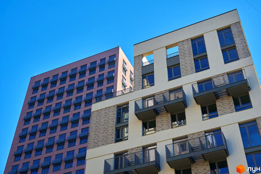 Високоповерхові будинки ЖК Будинок на Вавилових з балконами та панорамними вікнами на тлі блакитного неба. Архітектура житлового комплексу.