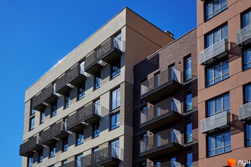 Будинок на Вавилових: багатоповерхові житлові будинки з фасадами світлого та темно-коричневого кольору, з балконами.