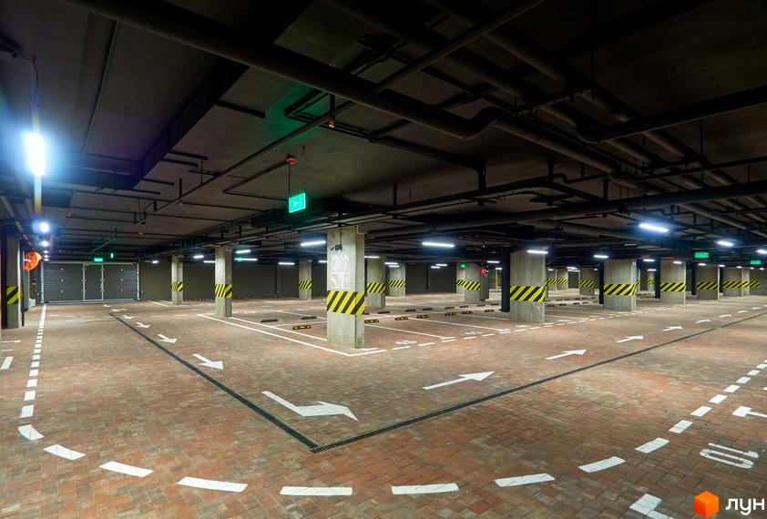 Підземний паркінг у житловому комплексі Будинок на Вавилових з розміткою та освітленням.