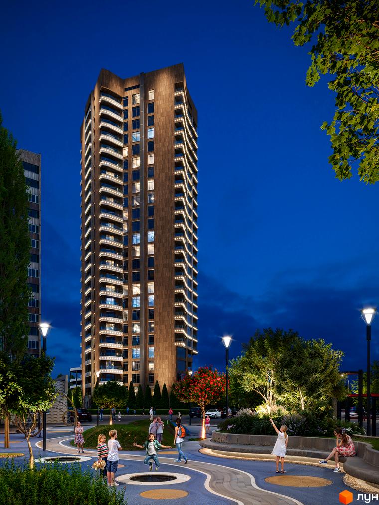 Житловий комплекс Grand Tower з підсвіченими балконами та фасадом, оточений доглянутою прибудинковою територією з дитячими майданчиками та деревами ввечері.