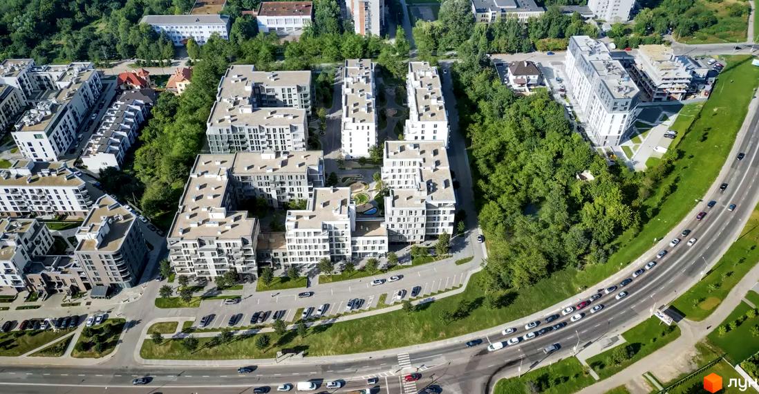 Вид з повітря на житловий комплекс Avalon Magnolia з білими багатоквартирними будинками та зеленою прибудинковою територією. Поруч проходить дорога з автомобілями.