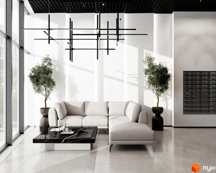 Інтер'єр холу житлового комплексу FREEDOM з білими стінами, диваном, журнальним столиком та рослинами.