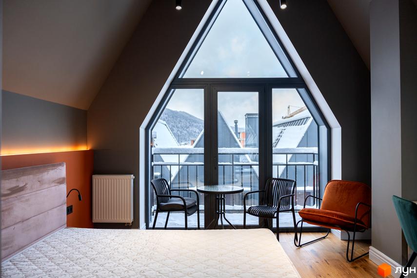 AMA FAMILY RESORT: затишна спальня з панорамним вікном та видом на засніжені дахи будинків. Сучасний дизайн інтер'єру.