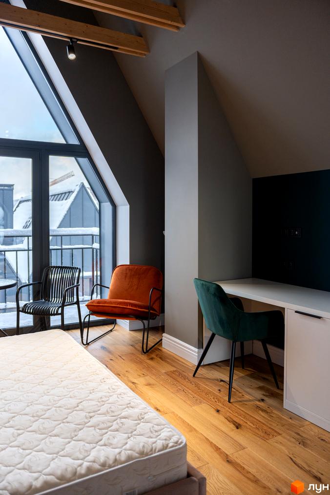 Інтер'єр спальні з великим вікном та видом на засніжені дахи. Затишна атмосфера для відпочинку в AMA FAMILY RESORT.