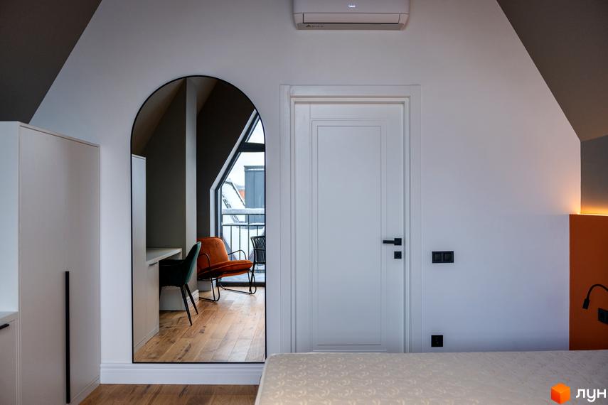 Інтер'єр номера в житловому комплексі AMA FAMILY RESORT з дзеркалом, що відображає зону відпочинку біля вікна.