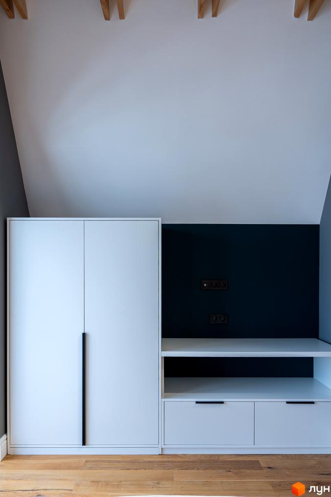 Сучасна шафа-купе та полиці з висувними ящиками в інтер'єрі спальні. Акуратний дизайн меблів підкреслює функціональність та естетику простору.