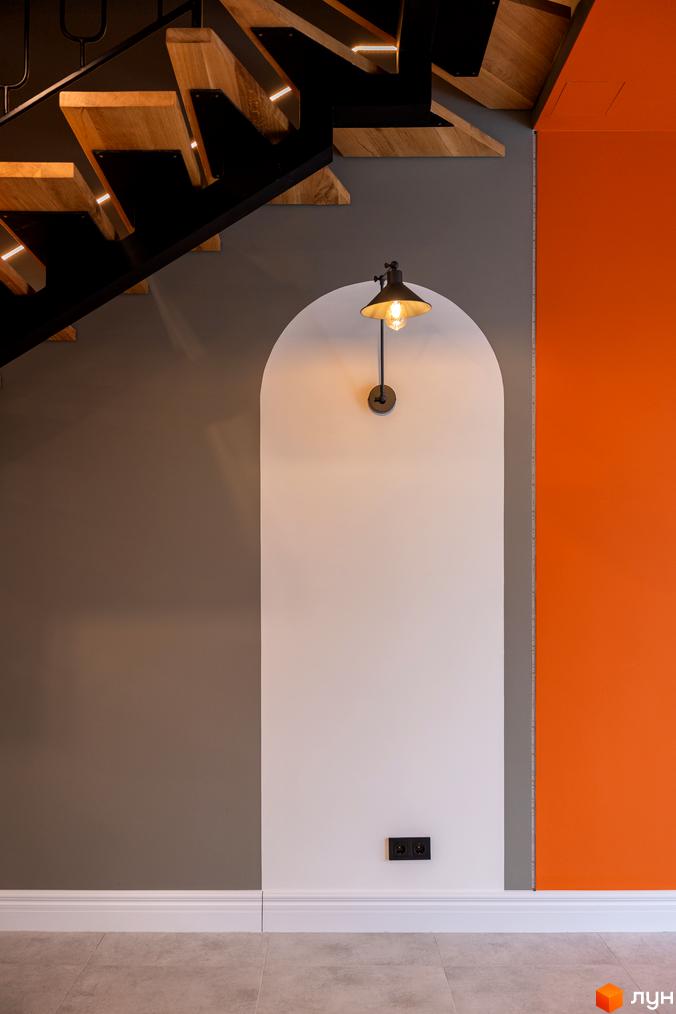 Інтер'єр будинку з дерев'яними сходами та яскравою помаранчевою стіною. Дизайн новобудови AMA FAMILY RESORT.