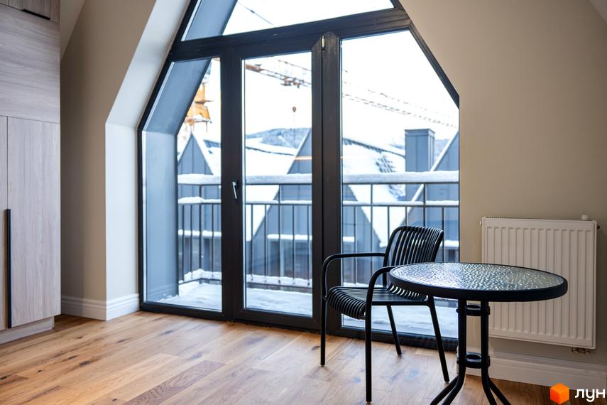 AMA FAMILY RESORT: інтер'єр кімнати з панорамним вікном та балконом, вид на засніжені дахи будинків. Сучасний житловий комплекс для вашого комфорту.