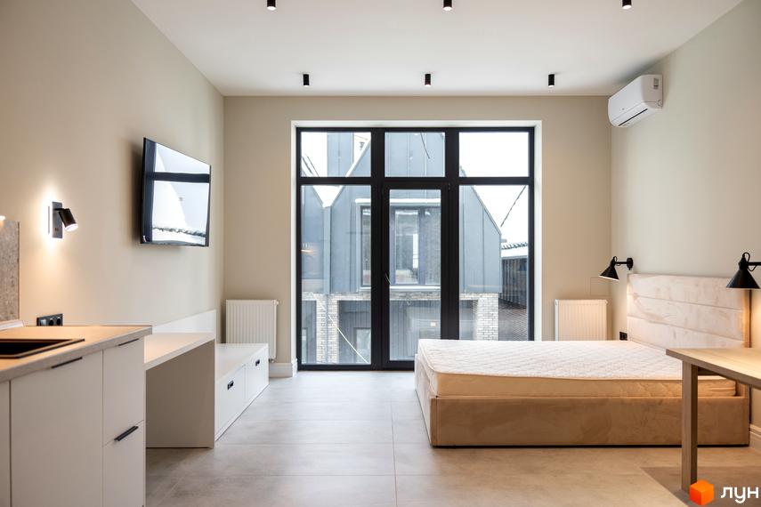 Сучасна студія з великим вікном та зручним ліжком, ідеальне місце для відпочинку та життя.