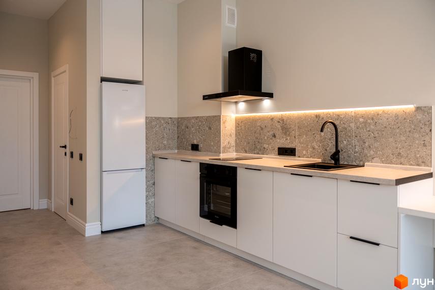 Інтер'єр кухні в новобудові AMA FAMILY RESORT з білими фасадами, кам'яною стільницею та чорною витяжкою. Сучасний дизайн кухні для комфортного життя.