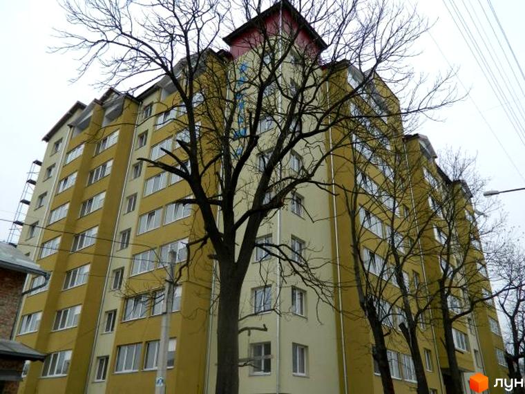 Зовнішній вигляд багатоквартирного будинку по вул. Ольги Кисілевської, 10. Світлі фасади та великі вікна.