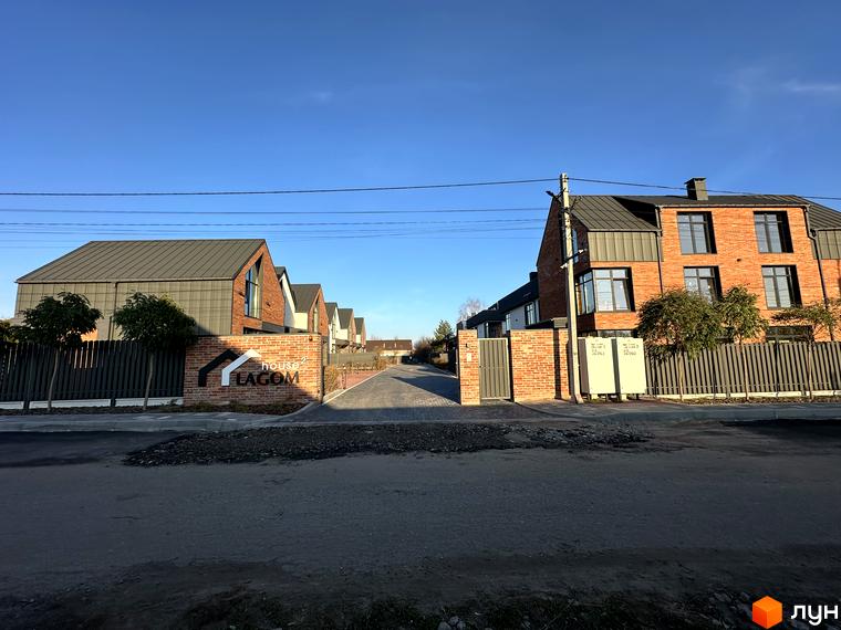 Таунхауси Lagom House - це цегляні будинки з темними дахами, розташовані вздовж вимощеної вулиці. Територія комплексу огороджена парканом.