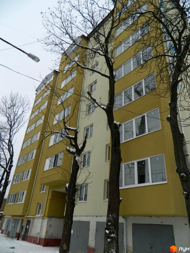 Зображення багатоповерхового будинку на вулиці Ольги Кисілевської, 10. Поруч з будинком ростуть дерева, видно сніг.