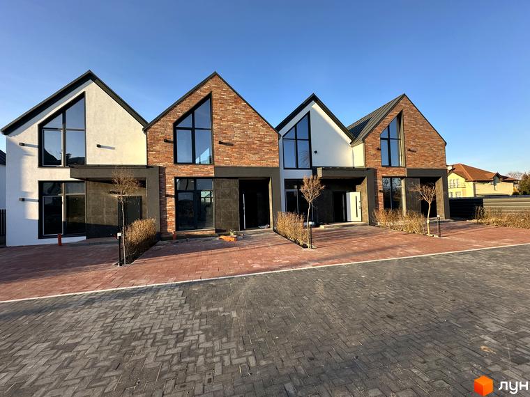 Таунхауси Lagom House: двоповерхові будинки з цегляним та білим фасадом, великими вікнами та червоною бруківкою перед будинком.