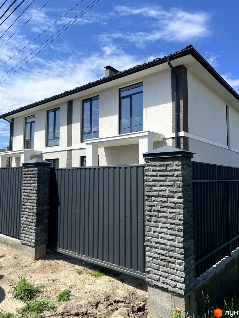 Дуплекси Four story з сірим парканом та цегляними стовпами. Зовнішній вигляд новобудови та прибудинкова територія.