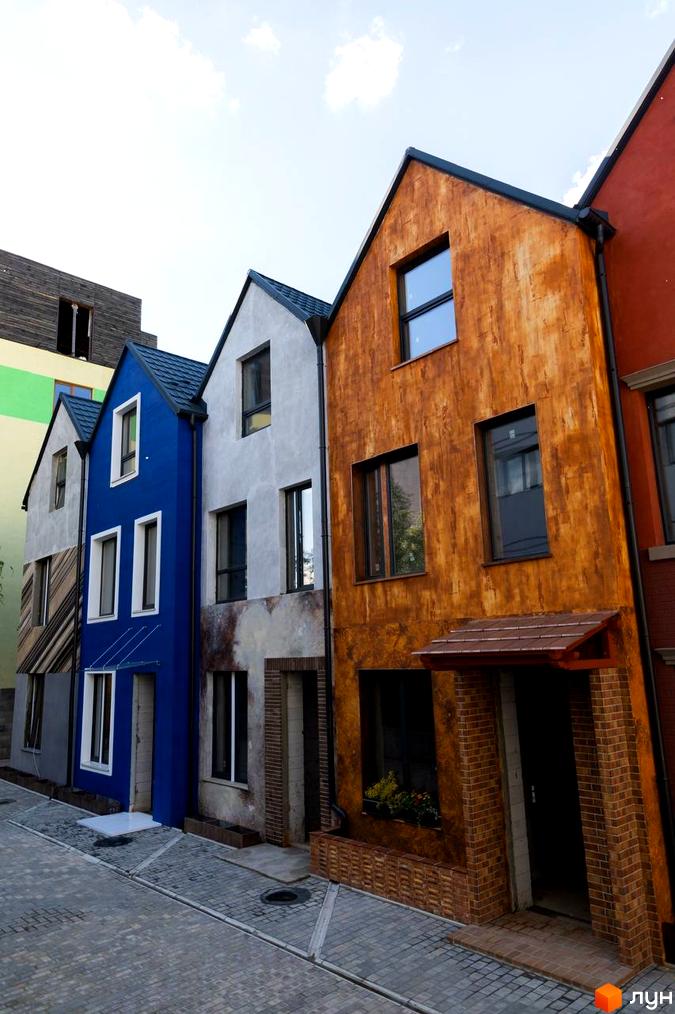 Котеджне містечко KADENYUK homes: фасади будинків у яскравих кольорах та брукована вулиця. Зовнішній вигляд новобудов та прибудинкова територія.