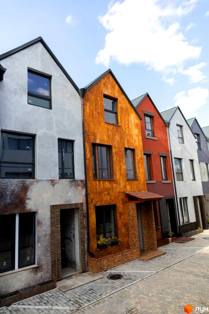 Котеджне містечко KADENIUK homes: фасади будинків у сірих та помаранчевих тонах, бруківка на території.