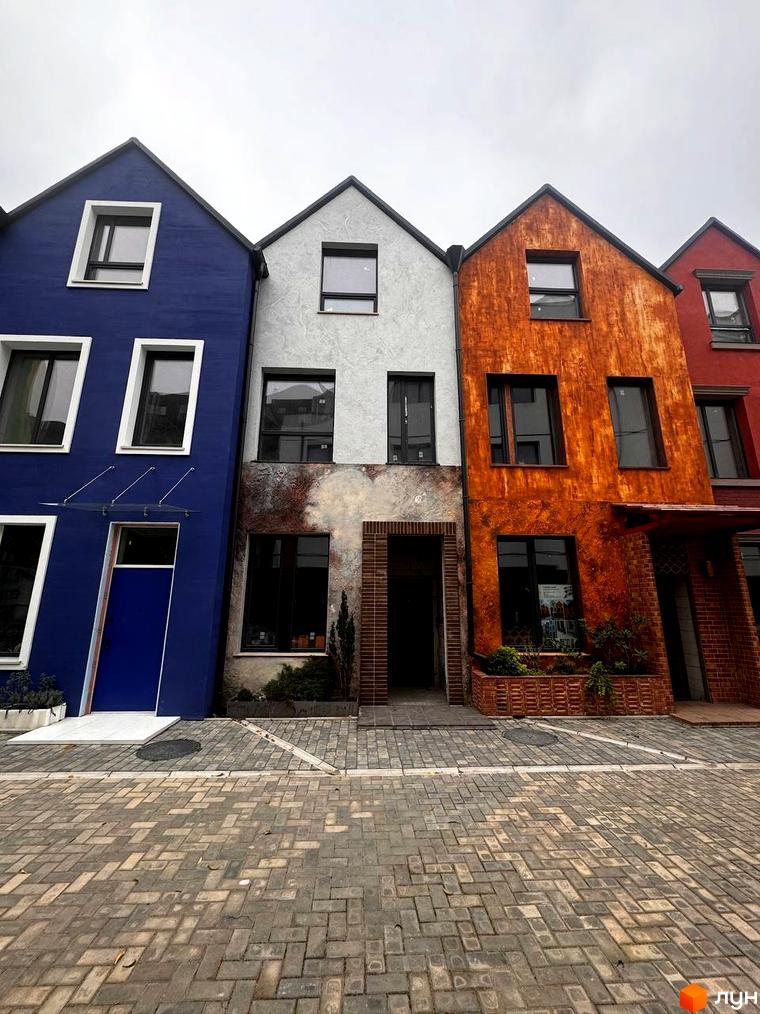 Зовнішній вигляд будинків житлового комплексу KADENYUK homes з яскравими фасадами та брукованою прибудинковою територією. Опис новобудови для SEO просування.