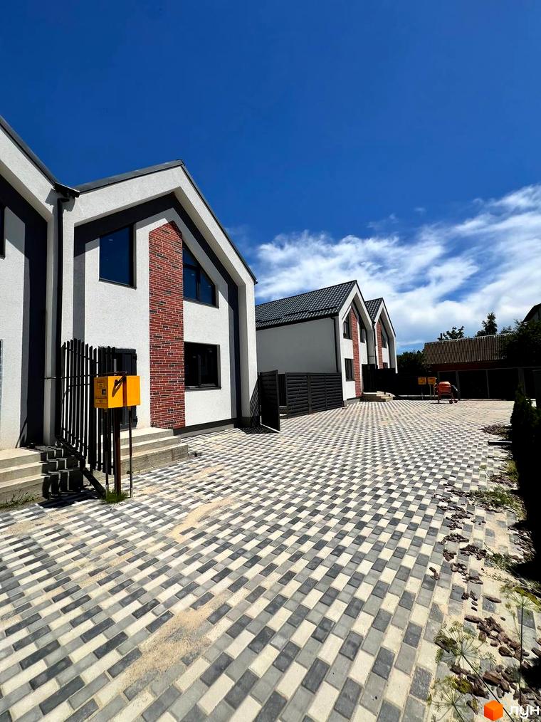 Дуплекси Флагман Стрижавка: фасади будинків з червоної цегли та білої штукатурки, вимощені сірою та білою плиткою двори.