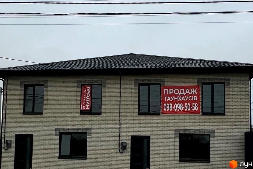 Двоповерховий будинок з цегляним фасадом та червоними банерами 