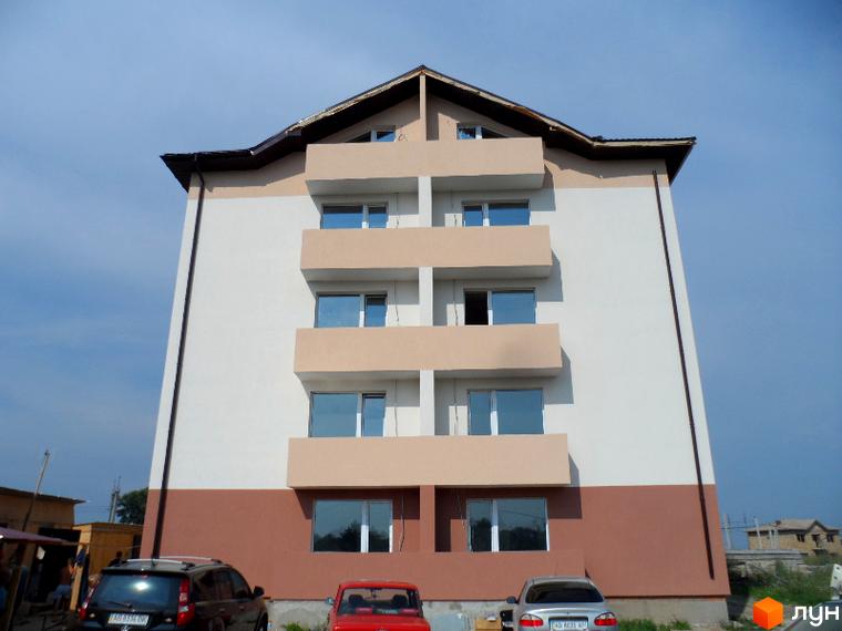 Зовнішній вигляд Житлового комплексу Фізкультурний. Багатоповерховий будинок з балконами та припаркованими автомобілями.