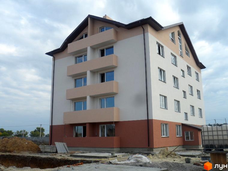 Зображення фасаду Житлового комплексу Фізкультурний. Багатоповерховий будинок з балконами та великими вікнами на фоні хмарного неба.