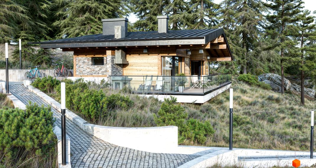 Котеджне містечко КМ Veres Hill: дерев'яний будинок з кам'яним фасадом та терасою, оточений соснами та облаштованою доріжкою з ліхтарями.