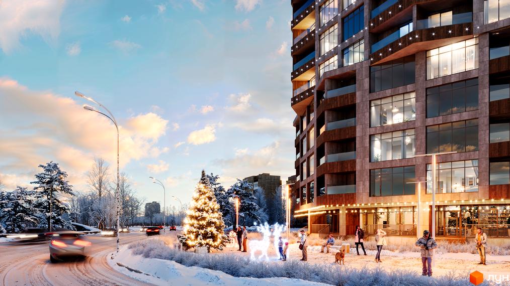 Житловий комплекс Grand Tower з фасадом з натурального каменю та скляними балконами. На прибудинковій території встановлено новорічну ялинку та декоративні фігури оленів.