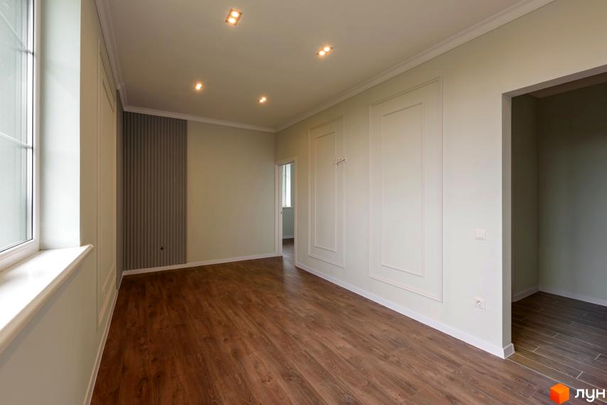 Інтер'єр просторої кімнати в Клубний будинок „Кагарлицький“ з дерев'яною підлогою, світлими стінами та точковим освітленням.