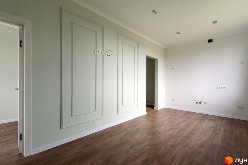 Клубний будинок „Кагарлицький“: світла кімната з дерев'яною підлогою та декоративними панелями на стінах. Проєкт новобудови з елегантним оздобленням.