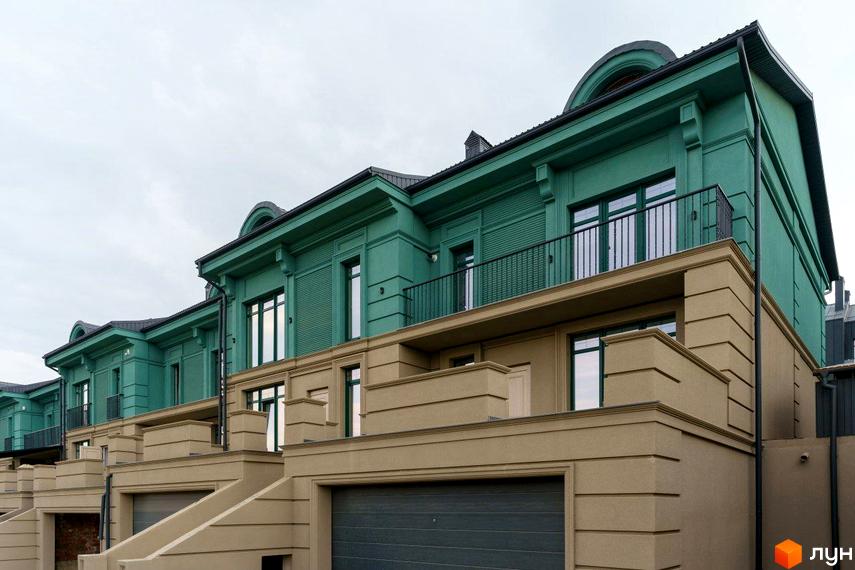 Ряд таунхаусів Таунхаус Green Life із зеленими верхніми поверхами та бежевими цоколями. На фасадах видно балкони та гаражі.