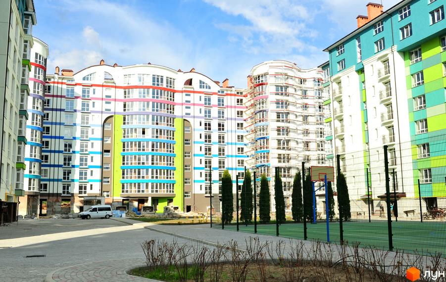 Зовнішній вигляд багатоповерхового будинку в Житловому районі Калинова Слобода. На території є баскетбольний майданчик та зелені насадження.