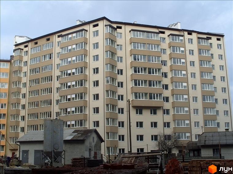Зображення багатоповерхового будинку на вулиці Федьковича. Житловий комплекс з великою кількістю вікон та балконів, поруч розташовані господарські будівлі.