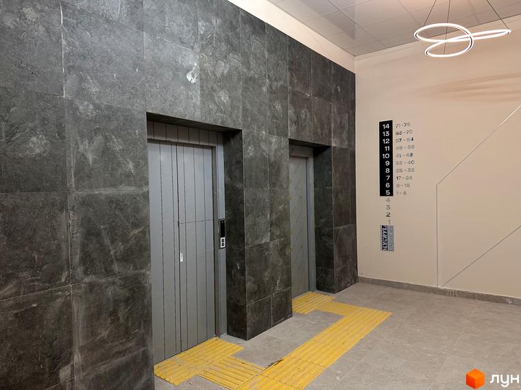 Два ліфти в сучасному будинку ЖК SOURANGE з мармуровим оздобленням стін та підлогою з тактильною плиткою.