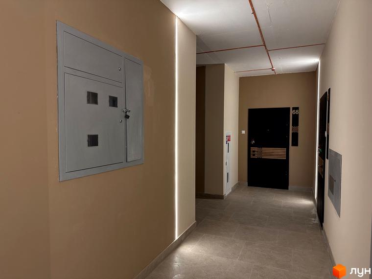 Фотографія коридору в Житловому комплексі SOVEREIGN. На стіні розташована шафа з замком та двері в квартири.