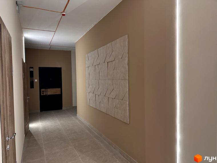 Інтер'єр коридору в Житловому комплексі СОУРЕНЖ з дверима та декоративною панеллю на стіні. Вигляд внутрішнього оздоблення будинку.