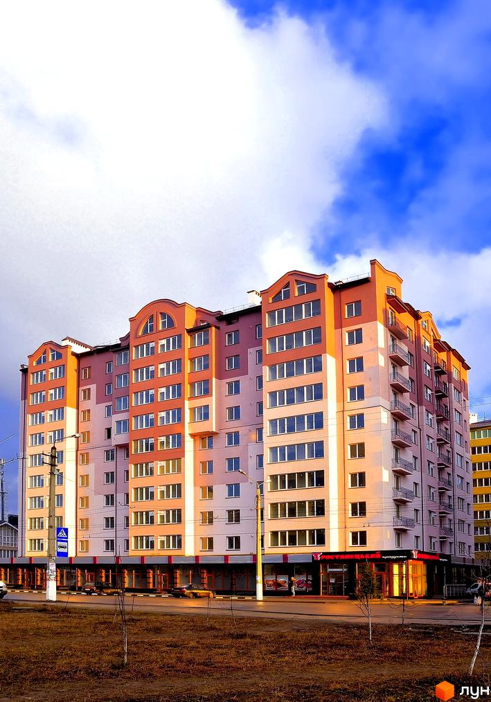 Фото фасаду багатоповерхового будинку по вулиці Симоненка, 31. На першому поверсі розташовані комерційні приміщення.