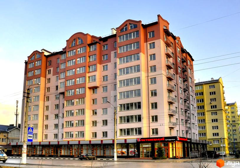 Зображення фасаду житлового будинку на вулиці Симоненка, 31. Багатоповерхова будівля з великими вікнами та балконами.