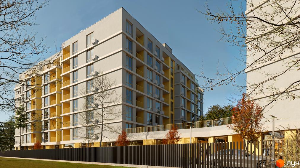 Багатоповерховий будинок Житловий комплекс Кленовий двір з сірим фасадом та жовтими балконами. Перед будинком зелений газон, огорожа та дерева.